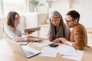 home insurance claim adjuster secret tactics Rock Roofing shingles big house winter time old couple talking with financial advisor