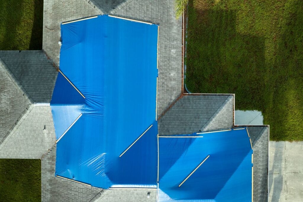 emergency roof repair blue tarp covering shingles roof